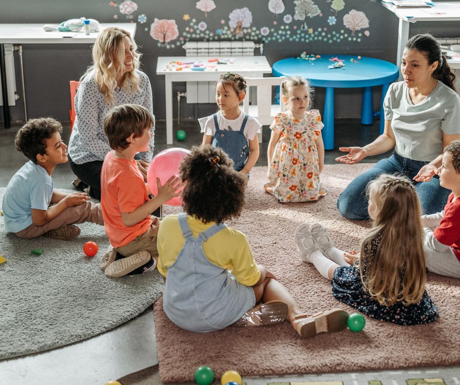 Kinder mit pädagogischen Fachkräften in einem Sitzkreis